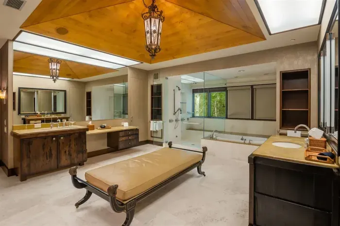 Wing 1 primary ensuite bathroom with his and hers vanity and toilets. One large walk-in closet and separate shower and tub.