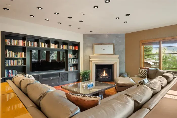 Family room with TV, fireplace, and breakfast table attached to the kitchen with access to the backyard, grill, and pizza kitchen.