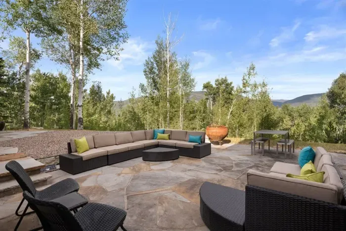 Large yard with multiple relaxation nooks surrounded by aspens.