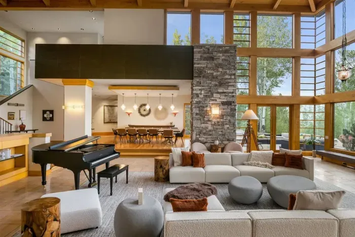 Gorgeous great room with 25 foot cherry ceilings, stone fireplace, and floor-to-ceiling windows.